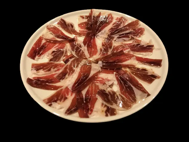 Foto von Traditioneller Jamón Ibérico (Luftgetrockneter Schinken) – fertig angerichtet